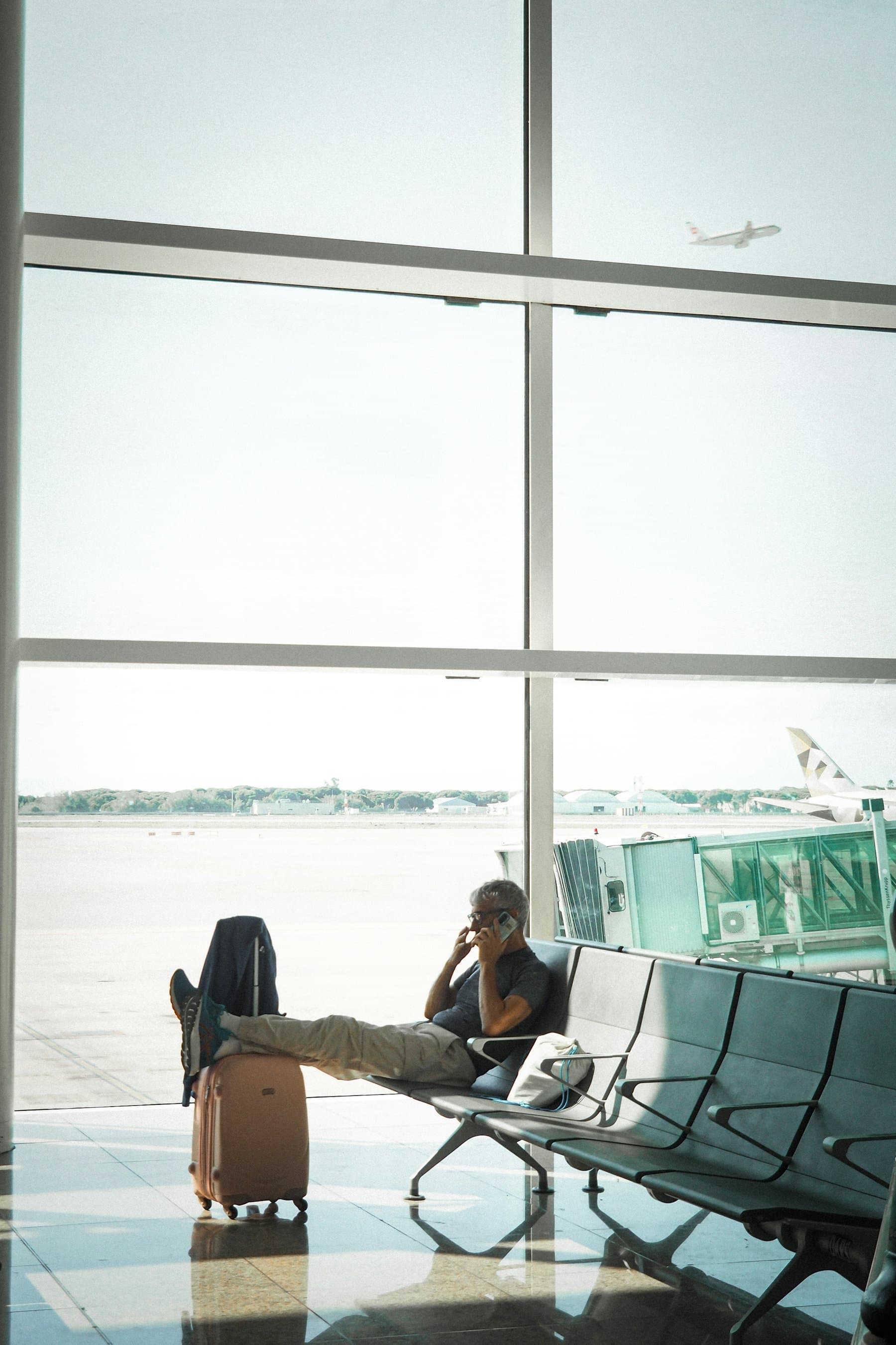 A traveller talking on a phone in an airport waiting area