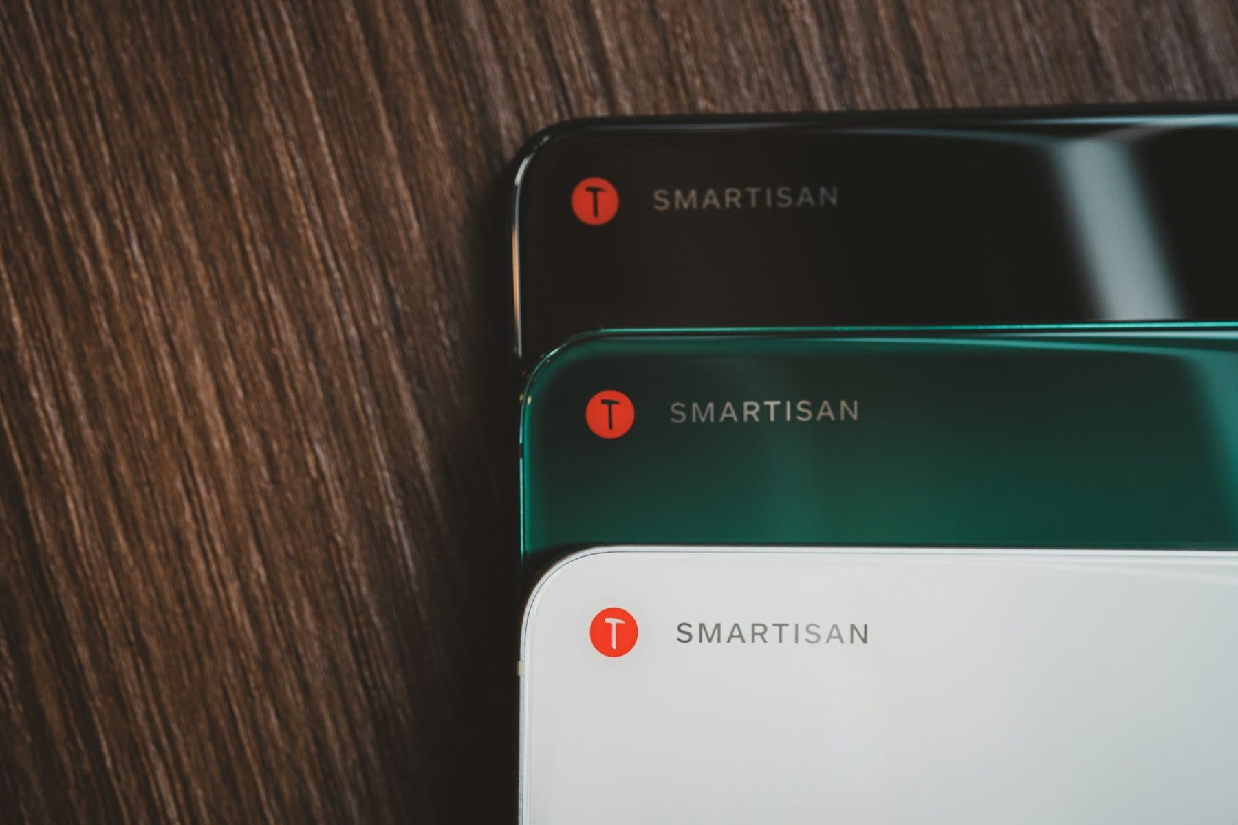 Several smartphones laid out in a row, seen close up