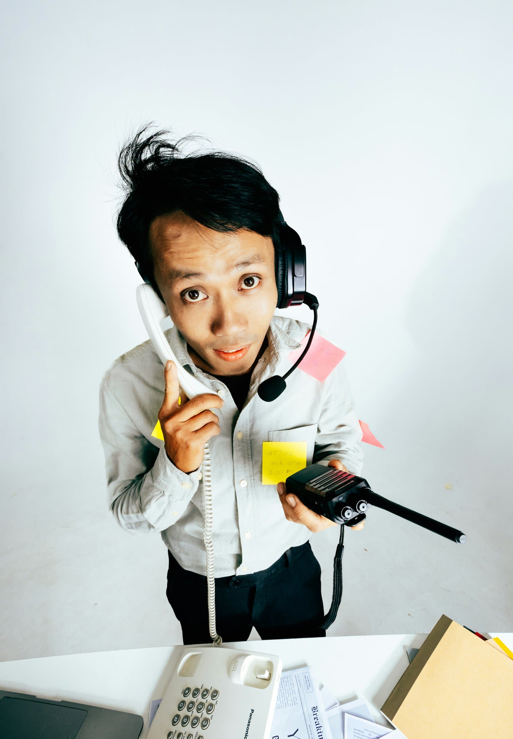 A person juggling several phones and communication devices at once