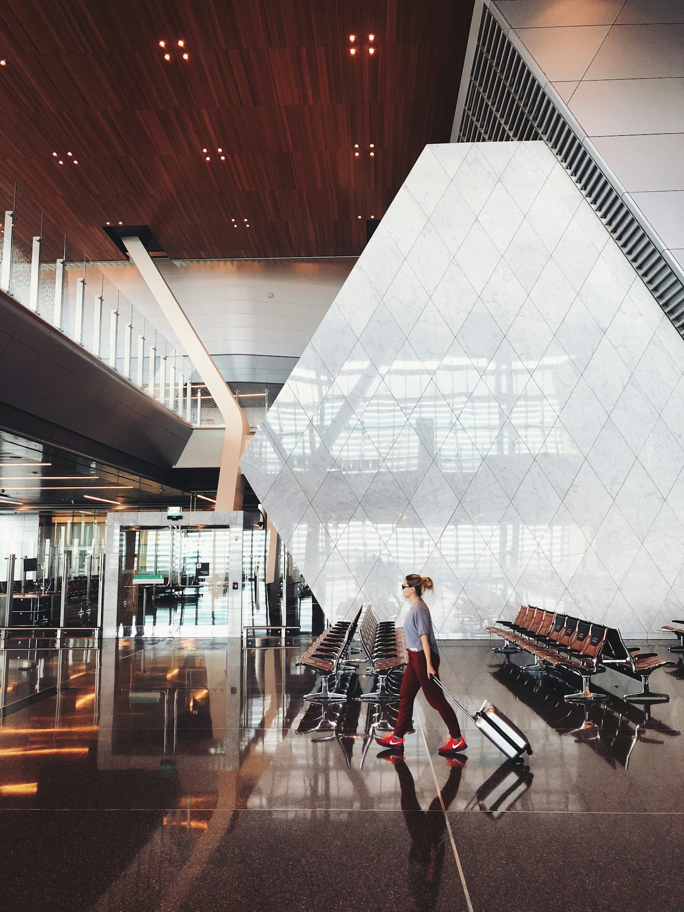 A traveller walking through an airport terminal with luggage