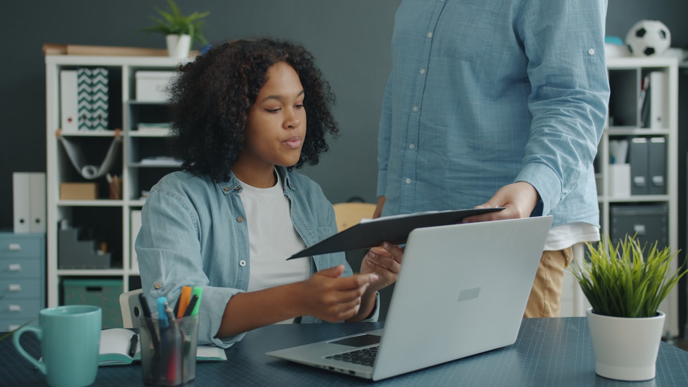 Two colleagues reviewing paperwork together at an office desk