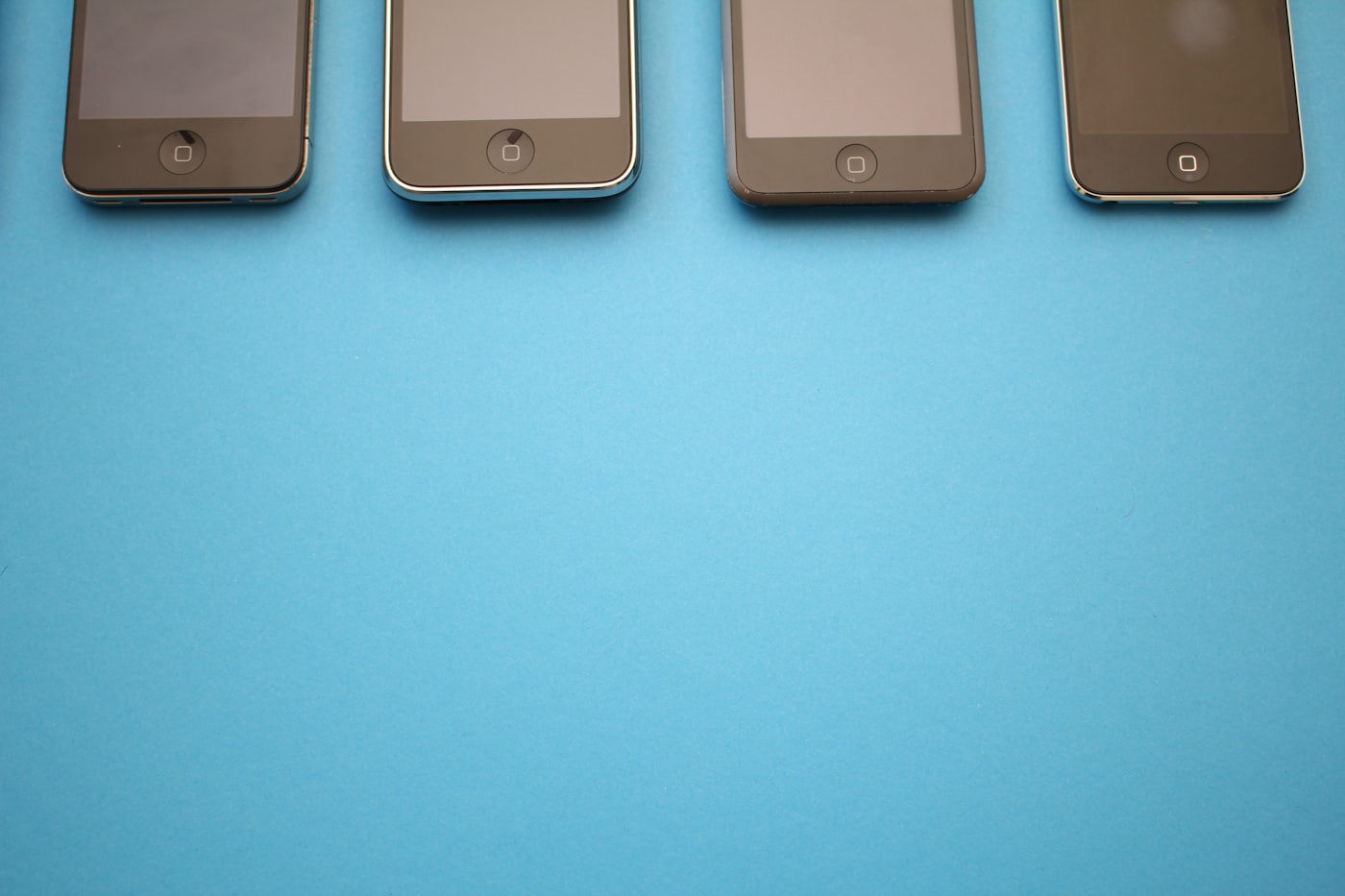 Four smartphones arranged on a flat surface