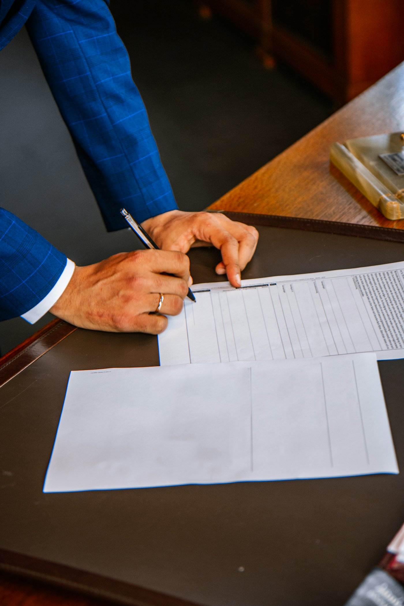 A person signing a printed form with a pen