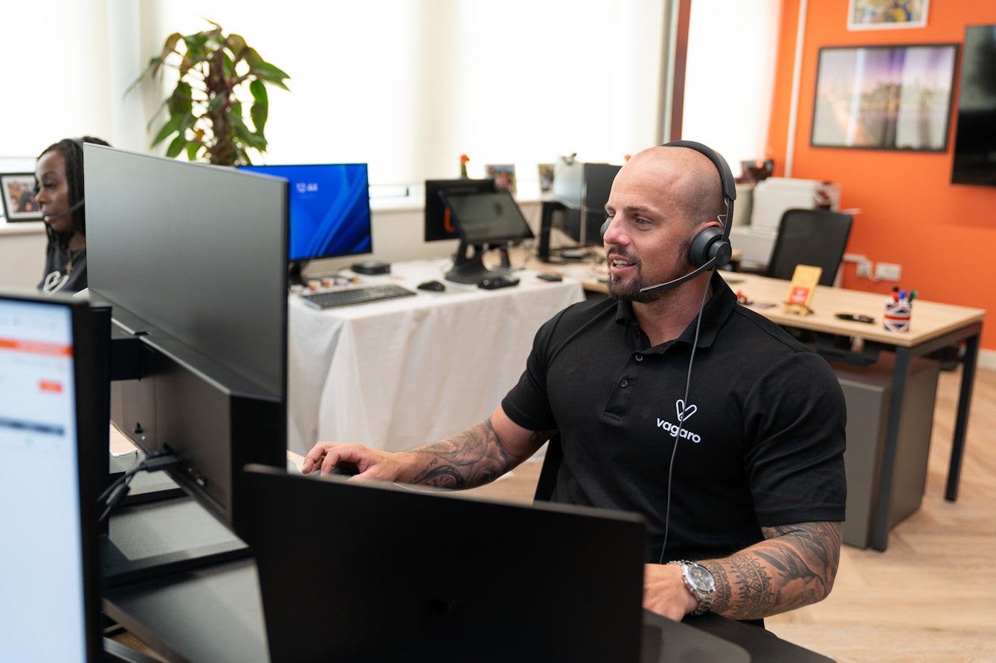 A support agent wearing a headset working at a computer
