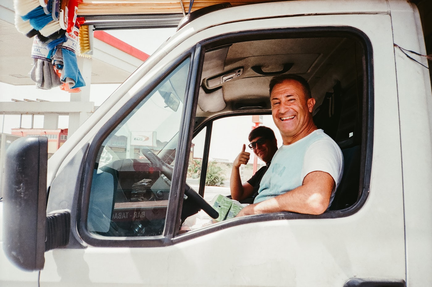 A driver giving a thumbs up from the window of a white work van